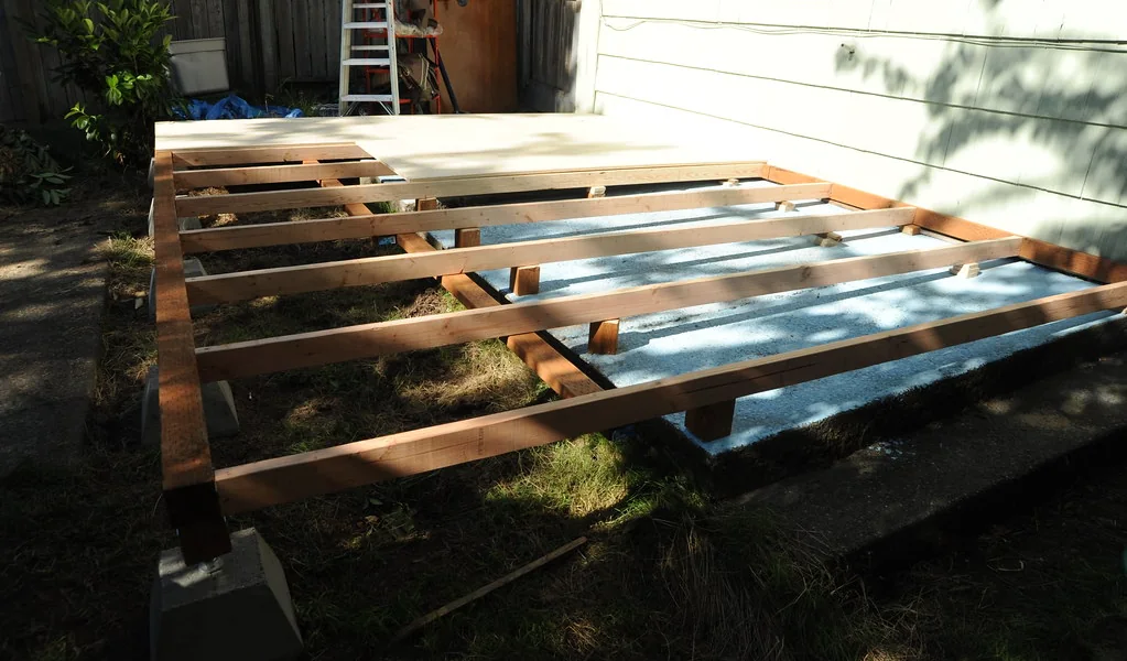 Deck frame of joists and beams resting on concrete pier blocks