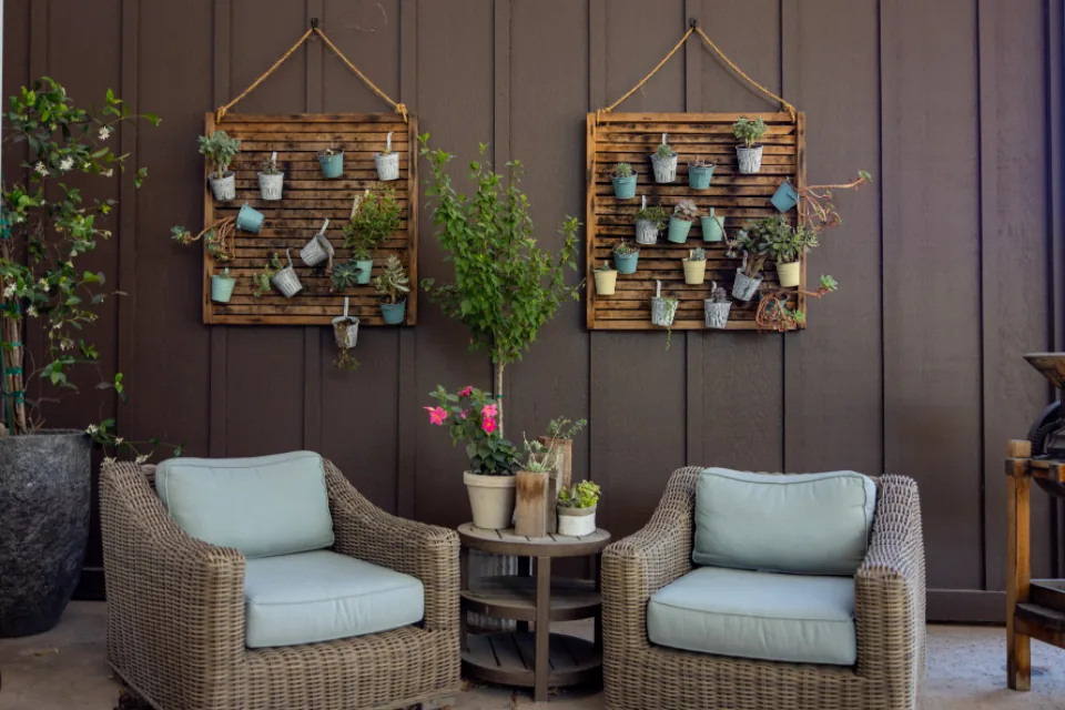 Wicker armchairs and potted plants on a sheltered patio